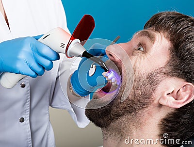 Doctor examines the oral cavity on tooth decay. Caries protection. Tooth decay treatment. Dentist working with dental Stock Photo