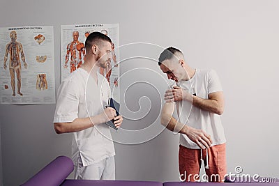 Doctor examines patient& x27;s back and appoints physiotherapeutic treatment. Stock Photo