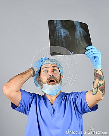 Doctor examines radiographic snapshot. Surgeon estimate damages. Hospital emergency. Doctor uniform. X-ray concept. X Stock Photo