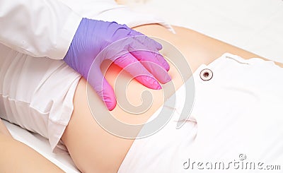 The doctor examines the stomach of the girl patient for the presence of appendicitis. The concept of abdominal pain on the right Stock Photo