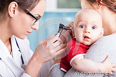 Doctor examining baby boy with otoscope Stock Photo