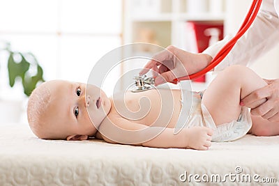 Doctor examining baby with stethoscope in clinic. Baby health concept Stock Photo