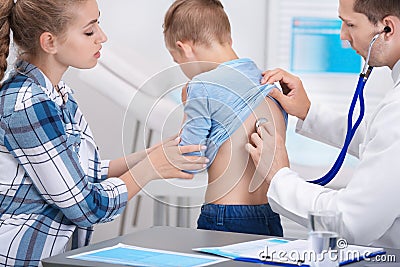 Doctor examining coughing little boy Stock Photo