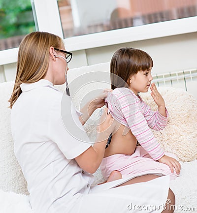 Doctor examining girl with stethoscope Stock Photo