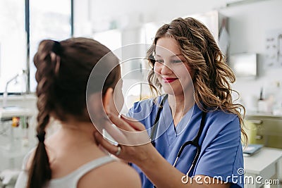 Doctor examining lymp nodes on neck of the young girl. Palpation of lymph nodes. Concept of preventive health care for Stock Photo