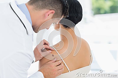 Doctor examining mole on back of woman Stock Photo