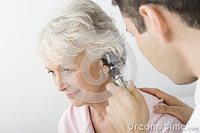 Doctor Examining Patient's Ear Using Otoscope Stock Photo