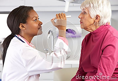 Doctor Examining Senior Female Patient's Eyes Stock Photo