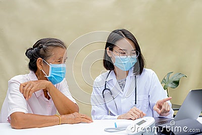 The doctor explained the health examination results to the elderly patient and guides friendly health care Stock Photo
