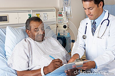 Doctor Explaining Consent Form To Senior Patient Stock Photo