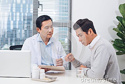 Doctor explaining prescription to male patient, healthcare concept Stock Photo