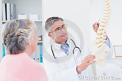 Doctor explaning anatomical spine to senior woman Stock Photo