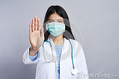 Doctor in face mask showing a hand stop symbol Stock Photo