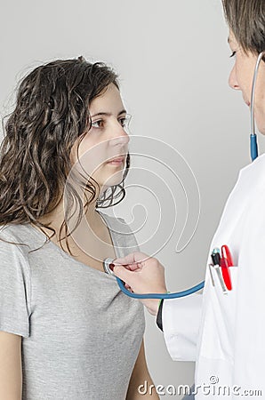 Doctor female auscultating young patient by stethoscope. Stock Photo