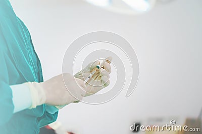Doctor filling syringe with medication, Hand holding syringe and medicine vial prepare for injection in operating room Stock Photo