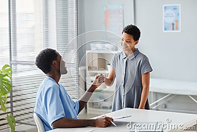 Doctor Fist Bumping Kid in Clinic Stock Photo