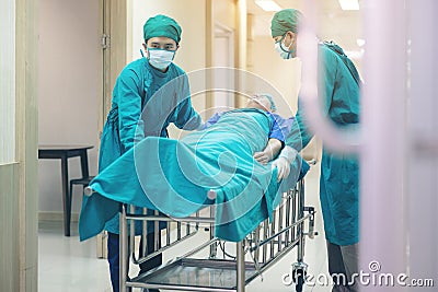 Doctor Getting their patient ready for the next procedure In the corridor, a medical team is pushing an emergency stretcher bed Stock Photo