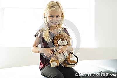 A doctor girl playing and cure bear at the pediatric Stock Photo