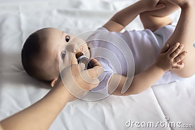 A doctor gives newborn baby rotavirus vaccine. Child immunization with little drop in clinic.Baby boy gets medicine from a little Stock Photo