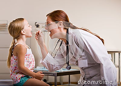 Doctor giving girl checkup in doctor office Stock Photo