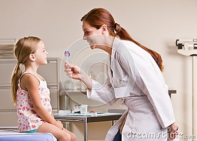 Doctor giving girl lollipop in doctor office Stock Photo