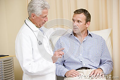 Doctor giving man checkup in exam room Stock Photo