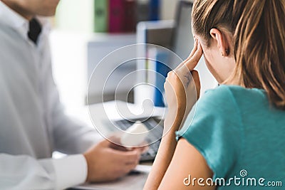 Doctor giving medical help to sick patient with bad headache or migraine. Stock Photo