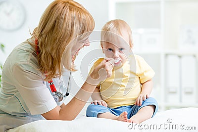 Doctor giving medicament to kid with a spoon Stock Photo