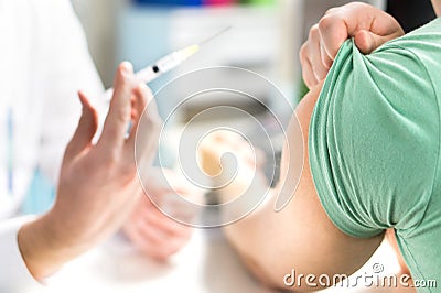 Doctor giving patient vaccine, flu or influenza shot. Stock Photo