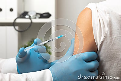 Doctor giving patient vaccine, flu shot. Doctor making a vaccination in the shoulder of patient Stock Photo