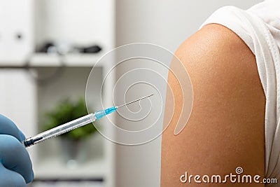 Doctor giving patient vaccine, flu shot. Doctor making a vaccination in the shoulder of patient Stock Photo