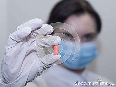 Doctor giving pills, woman in medical mask and gloves. The concept of the dose of drugs, vitamins, medical examination, Stock Photo