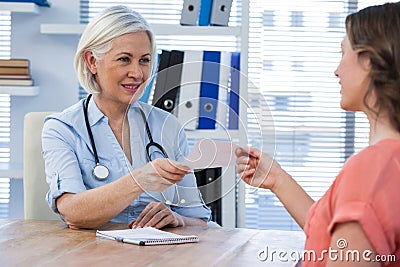 Doctor giving a prescription to her patient in medical office Stock Photo