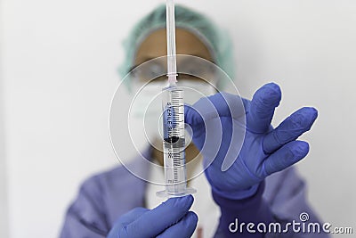 A doctor with gloves holds a syringe Stock Photo