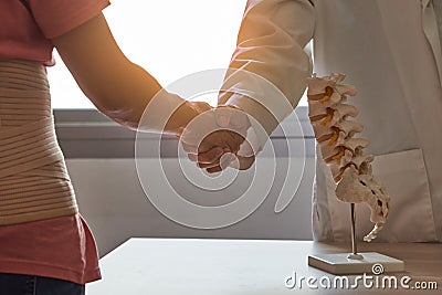 Doctor greeting with back pain patient in medical office Stock Photo