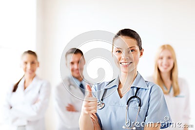 Doctor with group of medics showing thumbs up Stock Photo