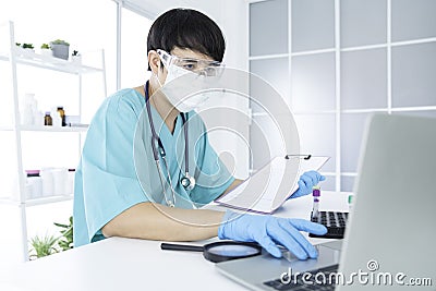 Doctor Hand holding Disease analysis results. The doctor worked hard in the office during the epidemic virus. Asian doctor holding Stock Photo