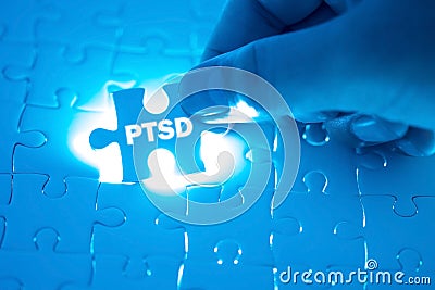 Doctor hand holding a jigsaw puzzle with PTSD - post traumatic s Stock Photo