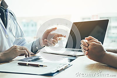 Doctor hand holding pen and talking to the patient about medication and treatment Stock Photo