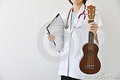 Doctor hand holding ukulele musical instrument, Music therapy Stock Photo