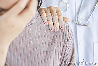 Doctor hand on shoulder of unhappy female patient comforting Stock Photo