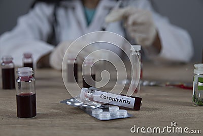 Doctor hand syringe on ampoule of coronavirus Stock Photo