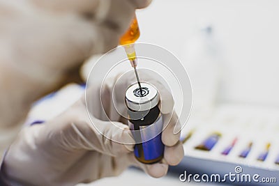 The Doctor hand using syringe sucking medicine from drug vial bottle. Stock Photo