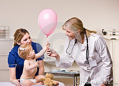 Doctor handing baby girl balloon Stock Photo