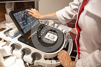 Doctor hands on control panel with keyboard of medical ultrasound diagnostic equipment in clinic Stock Photo