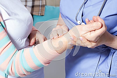 Doctor hands feeling pulse on female wrist, Female doctor measuring blood pulse of senior woman, Hands measuring blood preasure Stock Photo