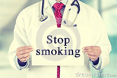 Doctor hands holding white card sign with stop smoking text message Stock Photo