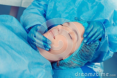 Doctor hands holds patient face examination before cosmetic plastic surgery Stock Photo