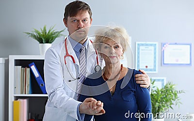 Doctor helps elderly woman to resist during illness Stock Photo