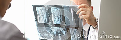 Doctor hold xray bone spine radiography in hand Stock Photo